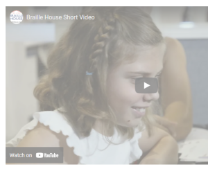 Picture is a screenshot of a video with a little girl smiling